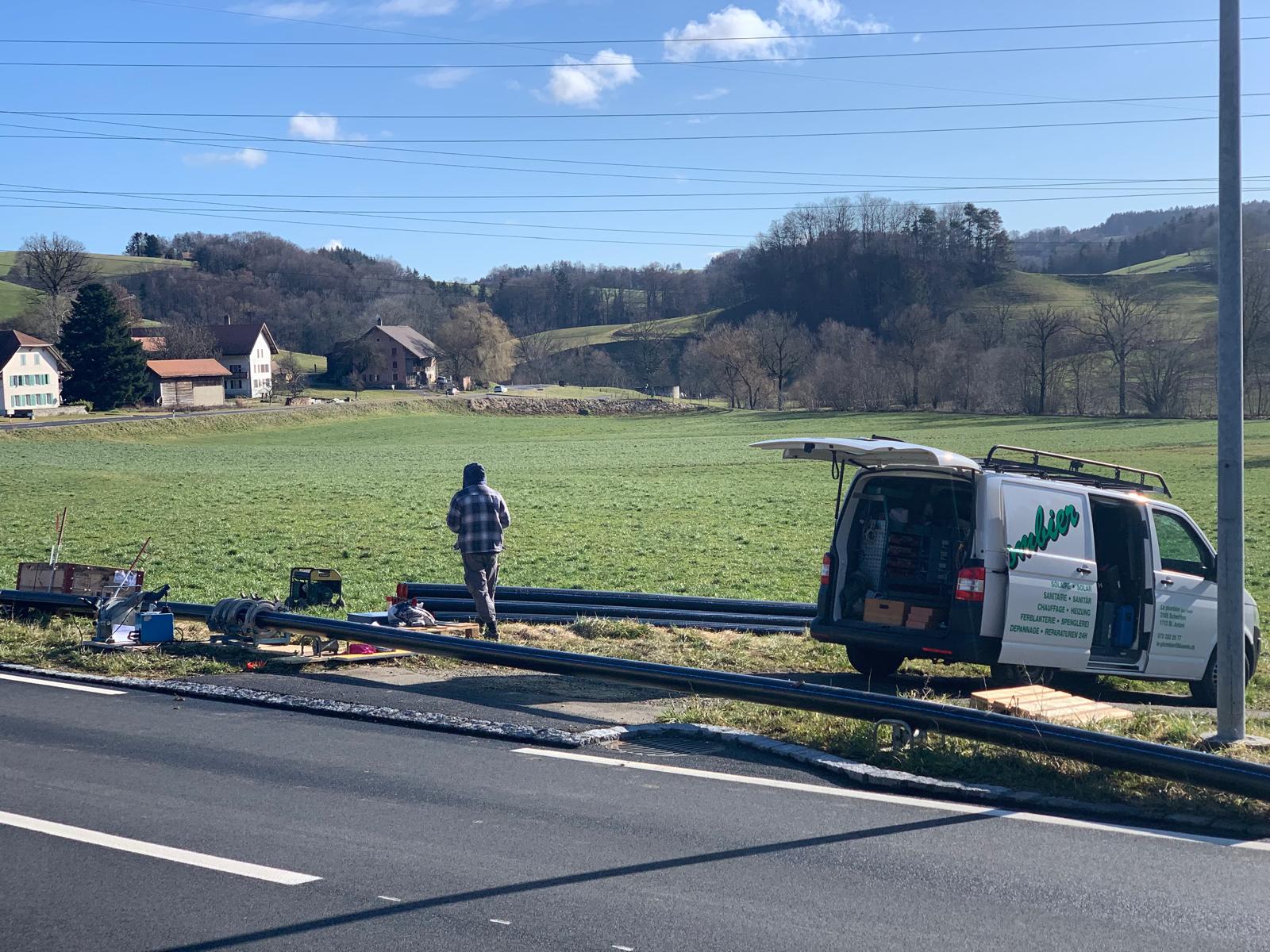 Rohrverlegung auf dem Feld mit Firmenwagen